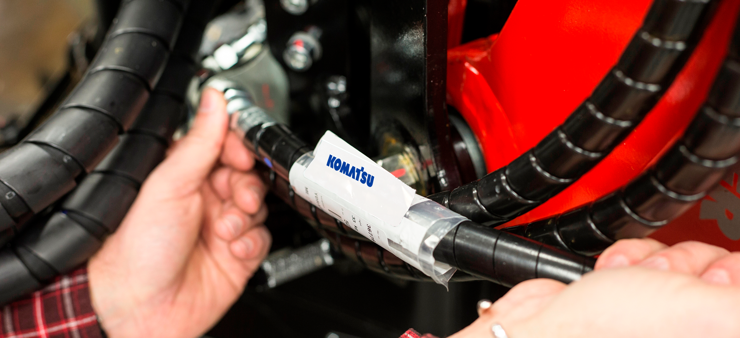 Mão fixando mangueira hidráulica